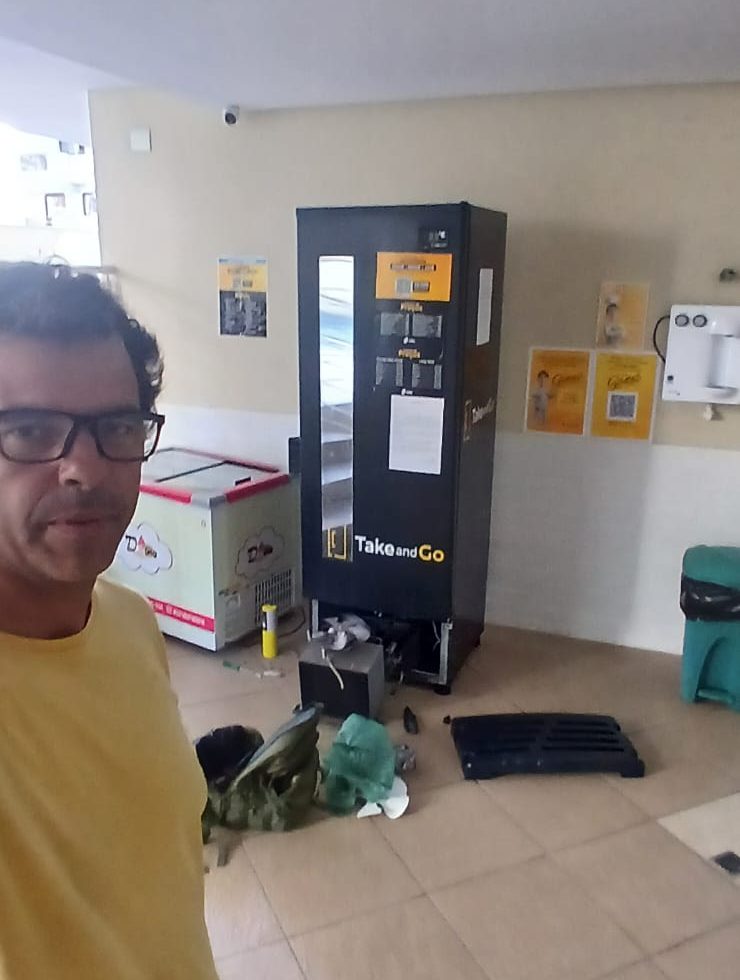 Rafael em atendimento de refrigeração comercial, com o equipamento aberto para manutenção